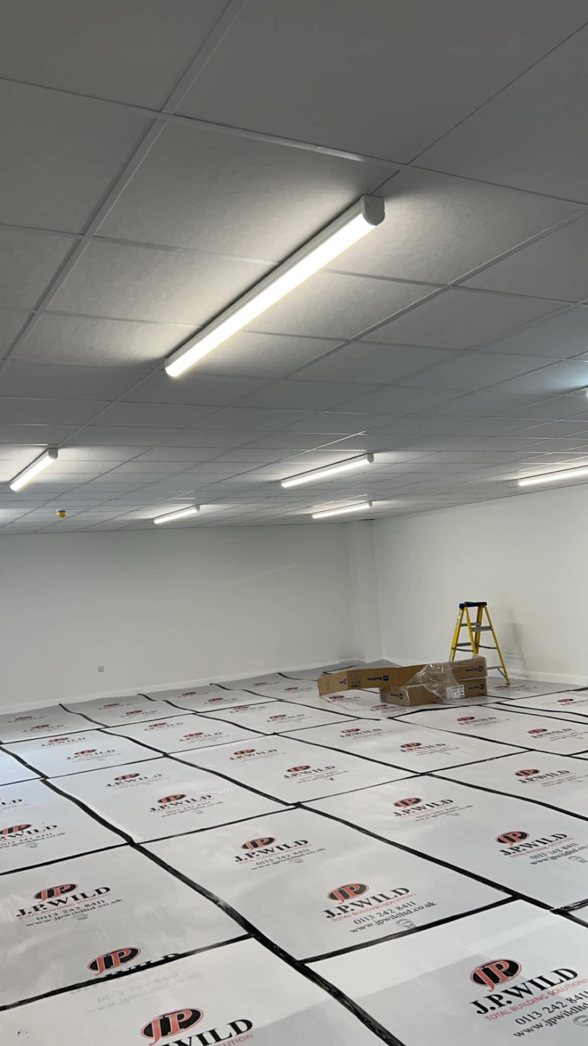 Suspended tile and grid ceiling installation in a commercial office space